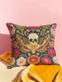 A square decorative throw pillow with a dark navy background and a linen-feel polyester texture. The design features a large, centrally-placed Death's Head hawkmoth with a detailed human skull marking on its thorax. The moth's wings are intricately patterned in shades of red, green, and gold. It is surrounded by a dense, symmetrical arrangement of colorful folk-art style flowers in vibrant shades of pink, red, and orange, with green leaves and vines. The print has a faux-embroidery appearance.