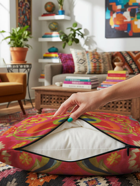 A vibrant pink square throw pillow featuring a green alien head wearing an orange cowboy hat. The alien is surrounded by colorful retro floral patterns in yellow, blue, and red. The style combines space cowgirl aesthetic with maximalist dopamine decor. The fabric has a premium linen texture. The cushion sits on a bright blue sofa, showcasing its bold, funky design. Perfect for weirdcore, sci-fi, or western themed rooms.