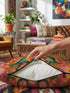 A square decorative throw pillow featuring a vibrant Hamsa hand and Evil Eye design on a hot pink background. The maximalist print includes bold blue, red, and green protection symbols with intricate details, offering a retro 70s and eclectic aesthetic. The fabric has a high-end linen texture with a hidden zipper. Available in 18x18 and 22x22 sizes.