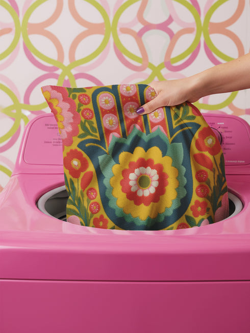 A square decorative throw pillow featuring a vibrant Hamsa hand and Evil Eye design on a hot pink background. The maximalist print includes bold blue, red, and green protection symbols with intricate details, offering a retro 70s and eclectic aesthetic. The fabric has a high-end linen texture with a hidden zipper. Available in 18x18 and 22x22 sizes.