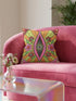 Black square pillow cover with a central eye medallion set inside a pink almond shaped mandorla. The psychedelic design surrounds the eye with red floral motifs, green leaves, and radiant orange and yellow sunburst rays. The smooth, linen-feel polyester print mimics high fidelity embroidery texture with no raised stitching. Divine feminine and sacred feminine eye pillow case, a feminist maximalist and whimsigoth cushion cover on a bold high-contrast black ground.