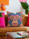 quare throw pillow cover with a faux embroidery 2D print of a stylized monkey face in large round yellow sunglasses with red flower lenses. The ape has electric blue fur with a hot pink brow and nose, on a navy background scattered with hot pink, yellow, and red flowers and green leaves. The print mimics raised stitching while staying flat and smooth, and shows on both sides. Cover only, available in 18 by 18 inch and 22 by 22 inch sizes.