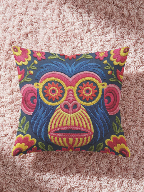quare throw pillow cover with a faux embroidery 2D print of a stylized monkey face in large round yellow sunglasses with red flower lenses. The ape has electric blue fur with a hot pink brow and nose, on a navy background scattered with hot pink, yellow, and red flowers and green leaves. The print mimics raised stitching while staying flat and smooth, and shows on both sides. Cover only, available in 18 by 18 inch and 22 by 22 inch sizes.