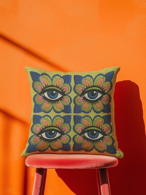 Square double-sided throw pillow cover featuring a vibrant faux embroidery design. Four stylized blue eyes sit inside retro pink, green, and orange floral shapes against a textured chartreuse yellow-green background. Made from premium faux linen polyester with a clean hidden zipper edge. This maximalist dopamine decor cushion cover is shown perfectly flat, highlighting the bold surrealist trompe-l'œil graphic print. Available in 18x18 or 22x22 inches.