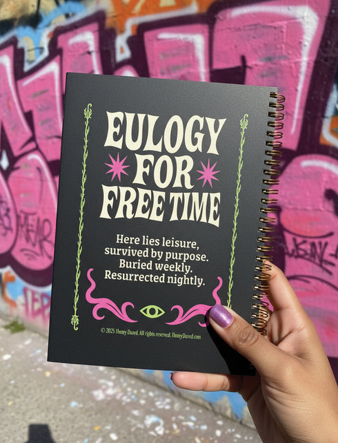 A black hardcover spiral planner. The cover features a vibrant, coffin-shaped frame in lime green and magenta pink, bordered by thorny vines. Inside the frame, the title "Obituary of Free Time" is written in a psychedelic 70s-style font. Below the title, a pink flower with a single green eyeball at its center blooms from a thorny stem. The planner is bound with a gold metal wire-o spiral on the left side. The design has a spooky cute, gothic floral aesthetic.