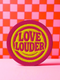 A round, 3-inch embroidered Love Louder patch designed with a vibrant, retro 70s aesthetic. The design features groovy, puffy-style text in a bright, sunny yellow thread, set against a bold magenta pink twill fabric background. The words 'LOVE LOUDER' are stacked to fill the center, encircled by concentric yellow rings that create a hypnotic, radiating effect. The entire circular patch is finished with a clean, durable merrowed border.
