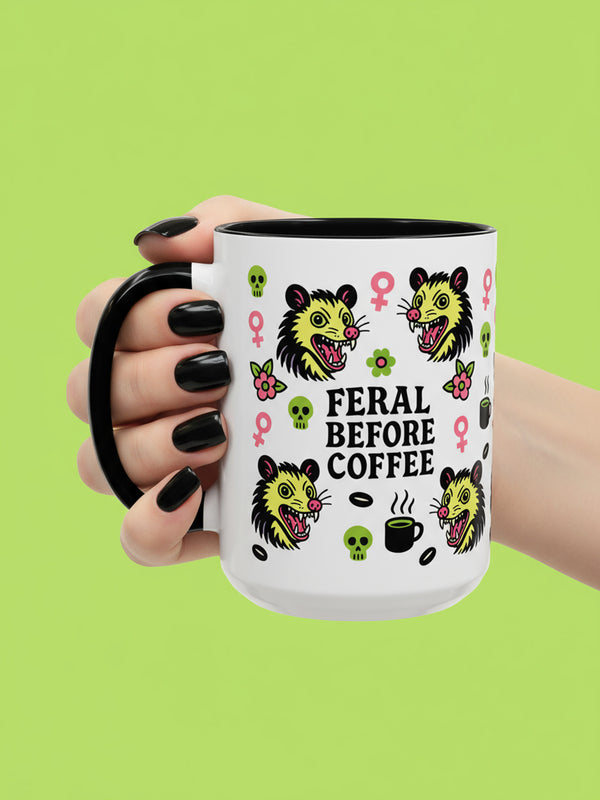 The Possum Feminist Feral Before Coffee Mug (11, 15oz) features a bold design with a sassy slogan and neon doodles, ideal for those who embrace morning chaos. Perfect neurodivergent gift for goth, feminist coffee lovers.