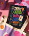 A black hardcover undated planner with black wire spiral binding. The front cover displays a bold, colorful typographic layout reading: "THINGS I AGREED TO WHILE TIRED". Surrounding text includes "LATE-NIGHT DECISIONS VOLUME 1", "ZERO MEMORY OF THIS.", and "A PRACTICAL GUIDE TO POOR TIMING." The back cover reads "INSIDE THIS DEEPLY SUSPICIOUS VOLUME:" above five colored banner rows detailing space for plans, notes for spirals, room for lists, daily proof time is fake, and a paper trail of mistakes.