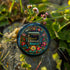 Round black pinback button with vibrant Mexican folk art-inspired embroidery design featuring red, yellow, blue and teal flowers surrounding a gold book spine with "Read Banned Books" text. Literary protest accessory with glossy finish and safety pin backing, available in 2" and 3" sizes.