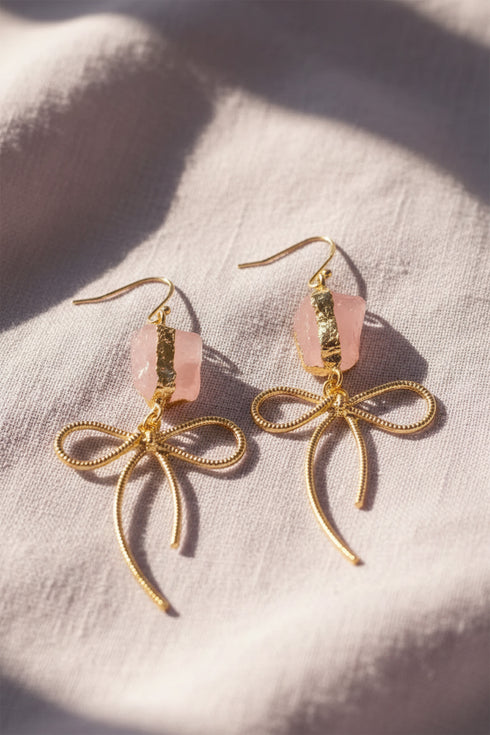 Earrings featuring pink rose quartz stones with 14k gold-plated brass bow designs, offering a sweet and sophisticated touch.