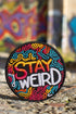 A round embroidered patch with a black background featuring the phrase “STAY WEIRD” in bold, multicolored lettering. "STAY" is stitched in a gradient of red, orange, and yellow, while "WEIRD" is in white. Surrounding the text are wavy, neon-like lines in blue, pink, yellow, and orange, creating a vibrant, psychedelic effect. The patch has a thick black border and is designed for iron-on or sew-on application, making it perfect for jackets, backpacks, denim, and accessories.