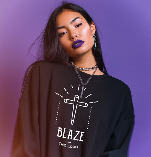 a sweatshirt featuring a minimalist cross design resembling a joint with the text "BLAZE THE LORD" underneath.