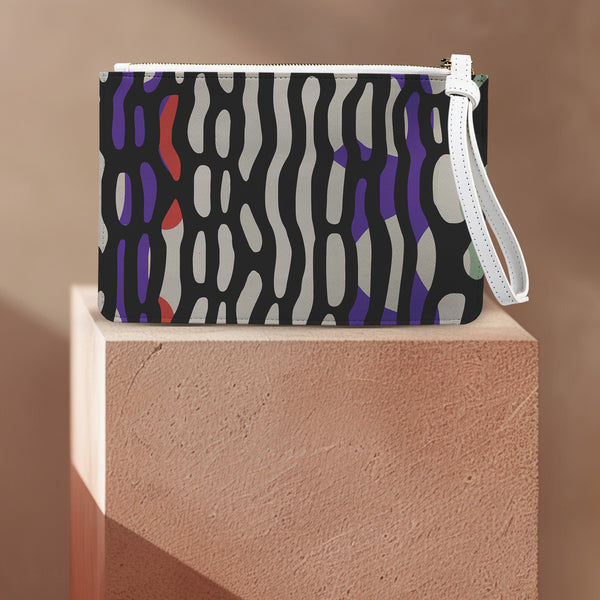 Rectangular wristlet clutch bag with psychedelic black, purple, red, and green pattern. White wrist strap and gold zipper visible