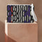 Rectangular wristlet clutch bag with psychedelic black, purple, red, and green pattern. White wrist strap and gold zipper visible