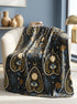 A rectangular velveteen minky blanket featuring a repeating dark academia pattern on a deep black background. The design includes gold and cream Ouija planchettes, each containing a blue all-seeing eye, a cream circle, and a light blue crescent moon framed by botanical leaves. Scattered between the planchettes are gold flowers with light blue stems, additional crescent moons, and small four-point stars. The reverse side of the blanket is made of a fluffy, textured off-white sherpa fleece.