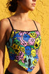 A sleeveless women's camisole top featuring a pointed handkerchief hemline often called a bandana top style. The fabric displays a vibrant all-over psychedelic print of distorting and melting smiley faces mixed with melting skulls. The color palette includes bright neon yellow, electric blue, hot pink, and lime green against a multi-colored background. The top features thin black adjustable spaghetti straps and black trim along the straight neckline. The fit is cropped and form-fitting.