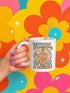 White ceramic 11oz coffee mug with a bold retro design that says “Witch, Please” above a drippy melting hand giving the middle finger.