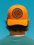 the back of a person wearing an orange baseball cap with the text "SMUT SCHOLAR" printed on it.