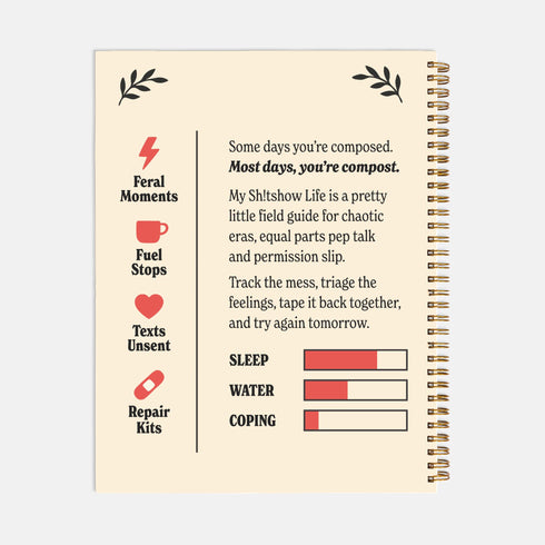 An 8.5 x 11 inch hardcover spiral-bound planner with a cream-colored cover featuring red and black folk art style floral illustrations. The cover reads "My Sh*tshow Life: A Field Guide" in a retro serif font. The planner has a durable satin matte laminated cover adhered to chipboard and a metal wire-o spiral binding available in gold or black. Interior pages are undated and include monthly and weekly layouts with sections for notes, to-do lists.
