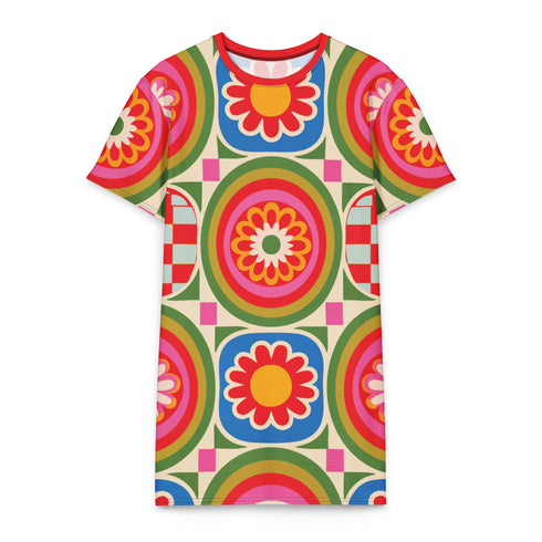 Short sleeve crew neck t-shirt dress on a cream background with an allover retro mod flower medallion print. Bold 60s daisies in red, yellow, and white sit at the center of concentric rainbow rings in lime green, hot pink, orange, and royal blue, with small magenta squares and tiny red checkerboard accents between the motifs. Above-the-knee straight fit silhouette in a 95 percent cotton, 5 percent elastane heavyweight stretch blend. Groovy retro flower power dress for dopamine dressing and easy summer outfi
