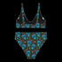 High-waisted bikini set featuring an all-over pattern of neon blue skulls with pink bows, pastel stars, and purple cherries on a dark olive green background. The top has a scoop neckline with wide straps, and the bottoms offer full coverage. A bold, punk-inspired swim look perfect for alternative fashion lovers and dopamine dressers.