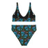 Two-piece high-waisted bikini set featuring an all-over print of blue skulls with purple bows and multicolored stars on a dark background. Includes a deep V-neck bikini top with wide straps and matching high-rise bottoms. Made from soft, stretchy fabric with a smooth black inner lining. The design combines bold, edgy graphics with a flattering retro-inspired silhouette.