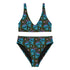 Two-piece high-waisted bikini set featuring an all-over print of blue skulls with purple bows and multicolored stars on a dark background. Includes a deep V-neck bikini top with wide straps and matching high-rise bottoms. Made from soft, stretchy fabric with a smooth black inner lining. The design combines bold, edgy graphics with a flattering retro-inspired silhouette.