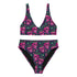 Two-piece bikini set featuring a bold pastel goth design with neon pink skulls wearing green bows, surrounded by multicolored stars on a deep black background. The set includes a plunging V-neck bikini top with wide straps and high-waisted bottoms for a flattering retro fit. Made of stretchy, soft material with a smooth black lining. This skull print swimsuit is ideal for alternative, edgy summer style with a playful punk twist.