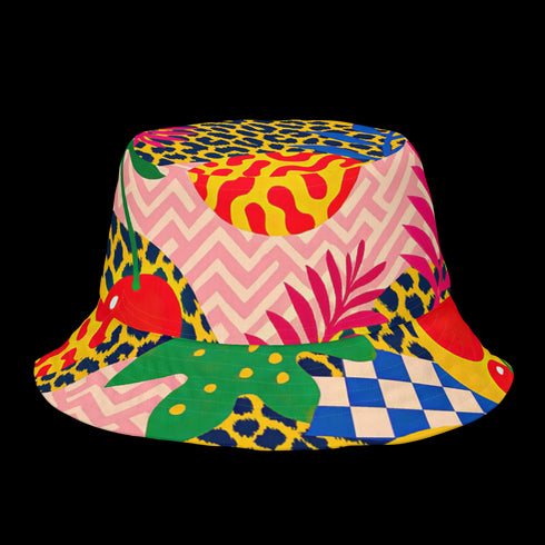 a reversible bucket hat. The visible side features a maximalist 70s-inspired pattern with bold orange, purple, and yellow abstract flowers on a black background with white checkerboard accents. The hat is made of a breathable, linen-feel polyester. The reverse side, hinted at on the brim's underside, has a vibrant Y2K psychedelic print with leopard spots and tropical fruit. This funky, colorful sun hat is a perfect dopamine dressing accessory for festival fashion.