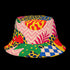 a reversible bucket hat. The visible side features a maximalist 70s-inspired pattern with bold orange, purple, and yellow abstract flowers on a black background with white checkerboard accents. The hat is made of a breathable, linen-feel polyester. The reverse side, hinted at on the brim's underside, has a vibrant Y2K psychedelic print with leopard spots and tropical fruit. This funky, colorful sun hat is a perfect dopamine dressing accessory for festival fashion.