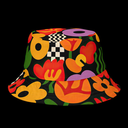 a reversible bucket hat. The visible side features a maximalist 70s-inspired pattern with bold orange, purple, and yellow abstract flowers on a black background with white checkerboard accents. The hat is made of a breathable, linen-feel polyester. The reverse side, hinted at on the brim's underside, has a vibrant Y2K psychedelic print with leopard spots and tropical fruit. This funky, colorful sun hat is a perfect dopamine dressing accessory for festival fashion.