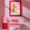 A fine art print of a glamorous rubber duck styled like Marilyn Monroe, with short curled blonde hair and soap bubbles. Displayed in a gold ornate frame against a pink wall with orange bead curtains.