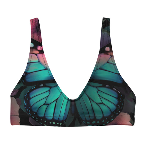 Scoop-neck bikini top with wide straps and a gothic butterfly wing design in deep jewel tones—teal, burgundy, and violet—set against black. Sports-bra style silhouette with bold symmetrical wing details across the chest. Floating above a turquoise pool, this swim top serves dreamy alt-girl energy for pool witches, celestial babes, and butterfly goths alike.