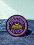 3-inch round embroidered iron-on patch in a cotton–polyester blend; black base with purple ring and gold accent ring; open book, gold crescent moon, tiny stars; curved purple text reads “LIBRARY COVEN”; merrowed edge. Witchy book lover patch for librarians, dark academia, and BookTok covens; makes a great gift for readers, witches, and spooky library pals.