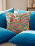 Square throw pillow cover with a printed faux embroidery design of a rooster wearing a white cowboy hat with red stars on a grass green background. The western chicken has a red comb and wattle, yellow beak and feet, and layered feathers in pink, green, orange, blue, and yellow with a rainbow striped tail. Pink and red flowers with yellow centers frame the bird. The stitched look is a flat 2D print on a smooth linen feel polyester cover with a hidden zipper, not raised embroidery.