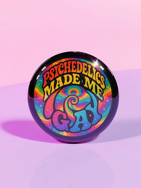 Round glossy pinback button measuring 2.25 inches featuring a vibrant rainbow psychedelic swirl with retro-style text that reads “Psychedelics Made Me Gay.” The background is a mix of rainbow waves and sparkles, with bold, colorful typography in orange, yellow, and blue. Made from durable tinplate with a safety pin backing, scratch-resistant mylar coating, and a high-gloss finish. Ideal for jackets, backpacks, or pride festival accessories.
