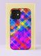 Front view of a dual layer tough phone case printed edge to edge with a glitchy rainbow gingham plaid. Crisscrossing bands of hot pink, magenta, electric blue, sunny yellow, red, teal, and purple overlap in a watercolor wash, with tiny halftone dots and brushy texture showing through the stripes. A soft violet and fuchsia haze settles over the lower half of the case. Bold Y2K dopamine color phone accessory with open ports and a precise camera cutout.