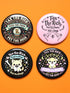 A collection of four retro-style 1.75 inch pinback buttons featuring the text "Tax the Rich" and "Pet the Dogs." Designs include: 1) A black pin with a crystal ball and gold filigree, 2) A pink pin with floral accents and a happy dog, 3) A black pin with a spooky chihuahua holding a bone, and 4) A black pin with a cute devil-horned puppy and lavender banner. High-gloss finish with psychedelic 70s typography. Perfect for battle vests or backpacks. Funny anti-capitalist dog lover gift.