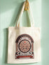 A beige canvas tote bag featuring a vintage-style circular crest design in rust orange and black. The text reads "Society of Childless Cat Dads" in an arch over a central illustration of a tabby cat face inside a geometric star and hexagon symbol. Below the cat, the text reads "Loyal to Cats, Suspicious of Fascists." A banner at the bottom reads "For Democracy." The design features occult and whimsigoth elements like crescent moons, columns, and fish bones.