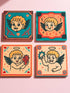 Set of four square ceramic coasters featuring a vampire cupid design in a pastel goth and traditional tattoo art style. The first coaster shows a fanged cherub on a teal background with red vines. The second features a cherub crying blood tears on a red background with daggers. The third depicts a cherub holding an anatomical heart on a peach background. The fourth shows a cherub with a spiked ring. Glossy glazed finish with cork backing. Ideal for spooky home decor and anti-valentine gifts.