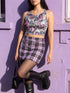 A sleeveless cropped tank top made from stretchy performance knit fabric. The all-over print features a dense, scattered pattern of pastel goth and creepy cute motifs over a light background. Graphics include pink and blue bats in flight, floating eyeballs with blue irises, pink skulls, and glossy vampire lips with sharp white fangs and tongues sticking out. The neckline is a high scoop and the armholes are curved. The fabric comes in either a matte finish or a sparkly silver glitter foil.