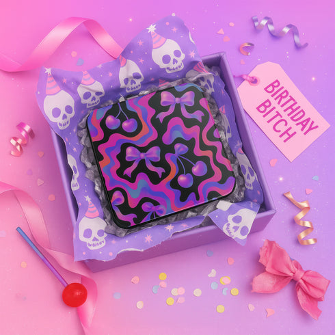 Square drink coaster featuring a bold Y2K-inspired pattern with gradient cherries and shiny pink bows on a black background with psychedelic pink, purple, and blue squiggle lines. Made from hardboard MDF with a non-slip cork backing and a high-gloss topcoat. Measures 3.74 by 3.74 inches. Water-repellent and heat-resistant, ideal for pastel goth, coquette, maximalist, and dopamine decor themes.