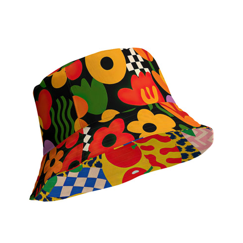 a reversible bucket hat. The visible side features a maximalist 70s-inspired pattern with bold orange, purple, and yellow abstract flowers on a black background with white checkerboard accents. The hat is made of a breathable, linen-feel polyester. The reverse side, hinted at on the brim's underside, has a vibrant Y2K psychedelic print with leopard spots and tropical fruit. This funky, colorful sun hat is a perfect dopamine dressing accessory for festival fashion.