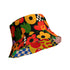 a reversible bucket hat. The visible side features a maximalist 70s-inspired pattern with bold orange, purple, and yellow abstract flowers on a black background with white checkerboard accents. The hat is made of a breathable, linen-feel polyester. The reverse side, hinted at on the brim's underside, has a vibrant Y2K psychedelic print with leopard spots and tropical fruit. This funky, colorful sun hat is a perfect dopamine dressing accessory for festival fashion.