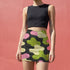 Honey Dazed bodycon mini skirt with abstract camo-inspired shapes in green, pink, black, and sage. The design mimics camouflage blobs with an amoeba-like twist in a high-waisted, stretchy silhouette. Made from eco-friendly performance fabric, this skirt is festival-ready, weirdcore-approved, and dance-floor durable. A subversive, soft-meets-tactical piece that blends retro rave energy with streetwear defiance.