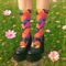 Colorful crew socks featuring a bold, fan-shaped mushroom pattern in orange, magenta, teal, yellow, and purple on a deep navy background. The design is vibrant and psychedelic, perfect for statement-making fashion. The socks are mid-calf length with reinforced heel and toe, made from a stretchy polyester, nylon, and spandex blend for comfort and durability.