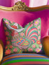 Square throw pillow cover with a printed faux embroidery design of a rooster wearing a white cowboy hat with red stars on a grass green background. The western chicken has a red comb and wattle, yellow beak and feet, and layered feathers in pink, green, orange, blue, and yellow with a rainbow striped tail. Pink and red flowers with yellow centers frame the bird. The stitched look is a flat 2D print on a smooth linen feel polyester cover with a hidden zipper, not raised embroidery.