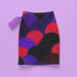 A colorful skirt with a pattern of overlapping circles in various shades of purple, red, and black.