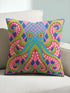 A square decorative throw pillow cover featuring a highly symmetrical bright octopus design. The octopus has a turquoise blue body with a diamond patterned head and eight curled tentacles detailed in bright pink and lime green. The background is a repeating diamond argyle pattern in royal blue and light pink. The artwork is a flat two dimensional print that mimics the textured look of intricate crewelwork embroidery. The pillow features a hidden zipper on the bottom edge. No insert included.