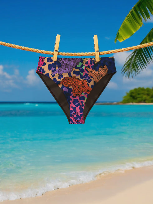 Psychedelic bikini bottom with multicolored tiger print on a neon leopard background; mid-rise cut with black lining and vibrant color blocking in purple, blue, pink, orange, and cream; made of recycled polyester and spandex blend with cheeky fit.